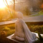 A statue of a meditating monk sits in our garden.